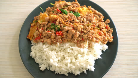 cerdo picado salteado con albahaca y huevo cubierto con arroz - estilo de comida asiática