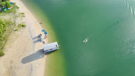 people enjoying swimming near a houseboat