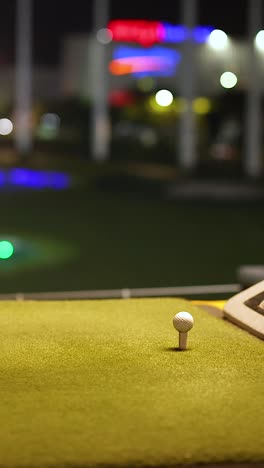 practicando el swing de golf en un campo de entrenamiento