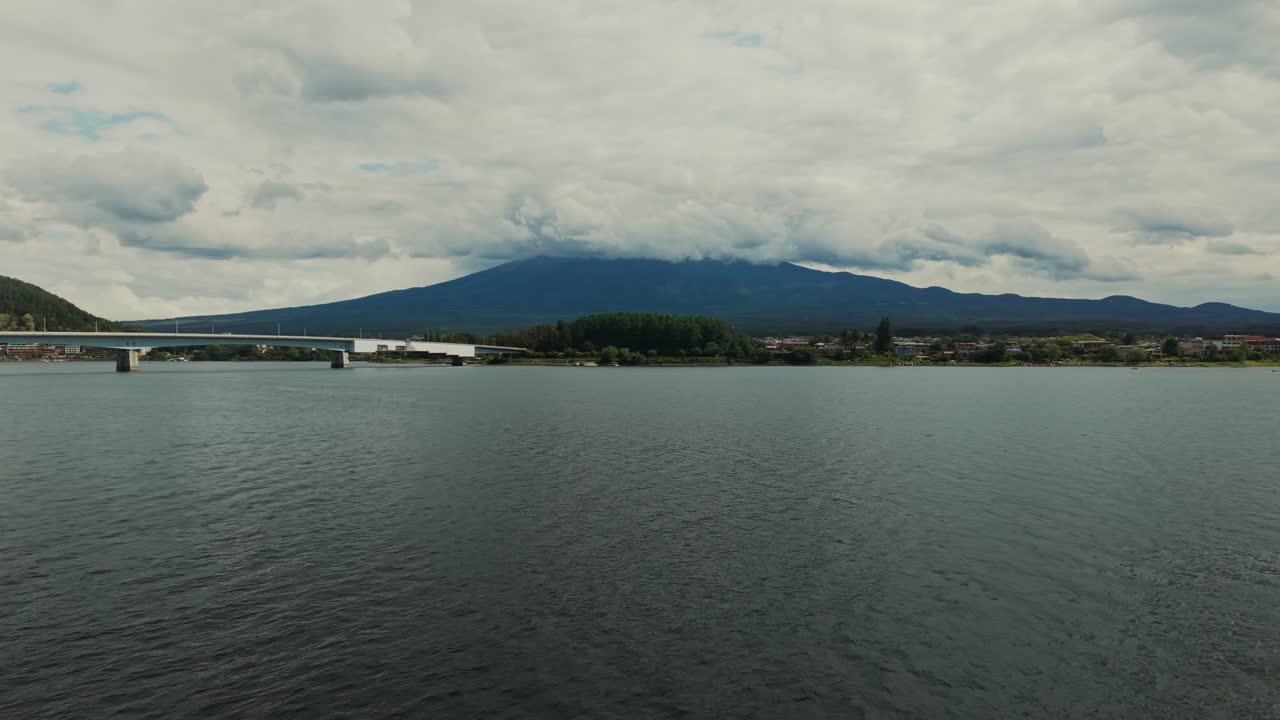 Mountain view with lake and bridge under cloudy sky