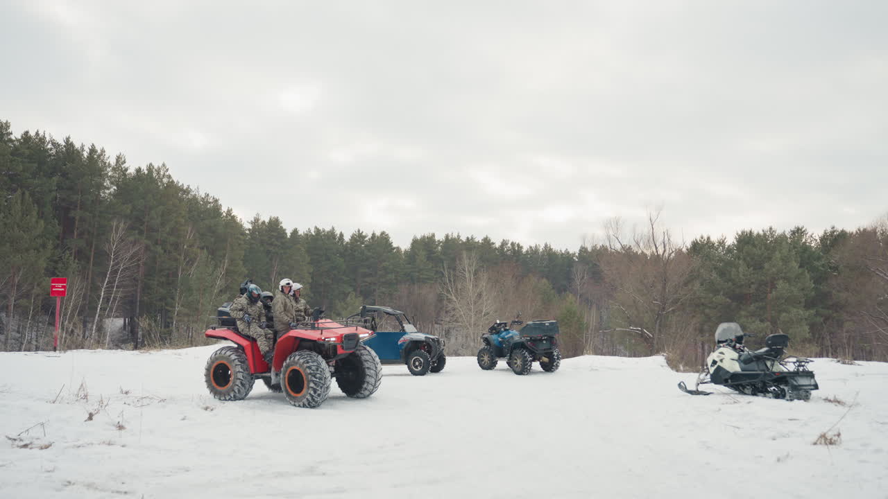 Piloti di ATV si radunano. Raduno su campo innevato per un'avventura fuoristrada. Piloti con ATV si preparano su terreno innevato. Squadra di appassionati di ATV che organizza l'attrezzatura su un campo innevato prima del giro.
