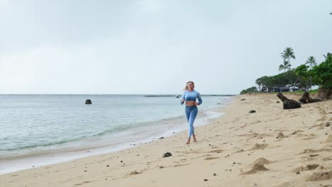 female running down the beach in fitness attire