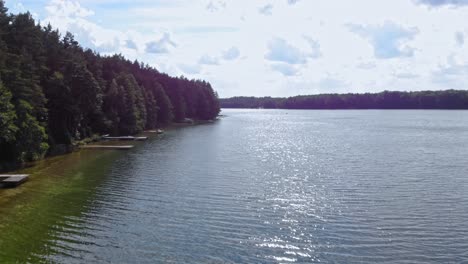 Drone-low-altitude-dolly-shot-over-lake-Jezioro-Gwiazdy-in-Borowy-Młyn,-Pomeranian-Voivodeship,-Poland
