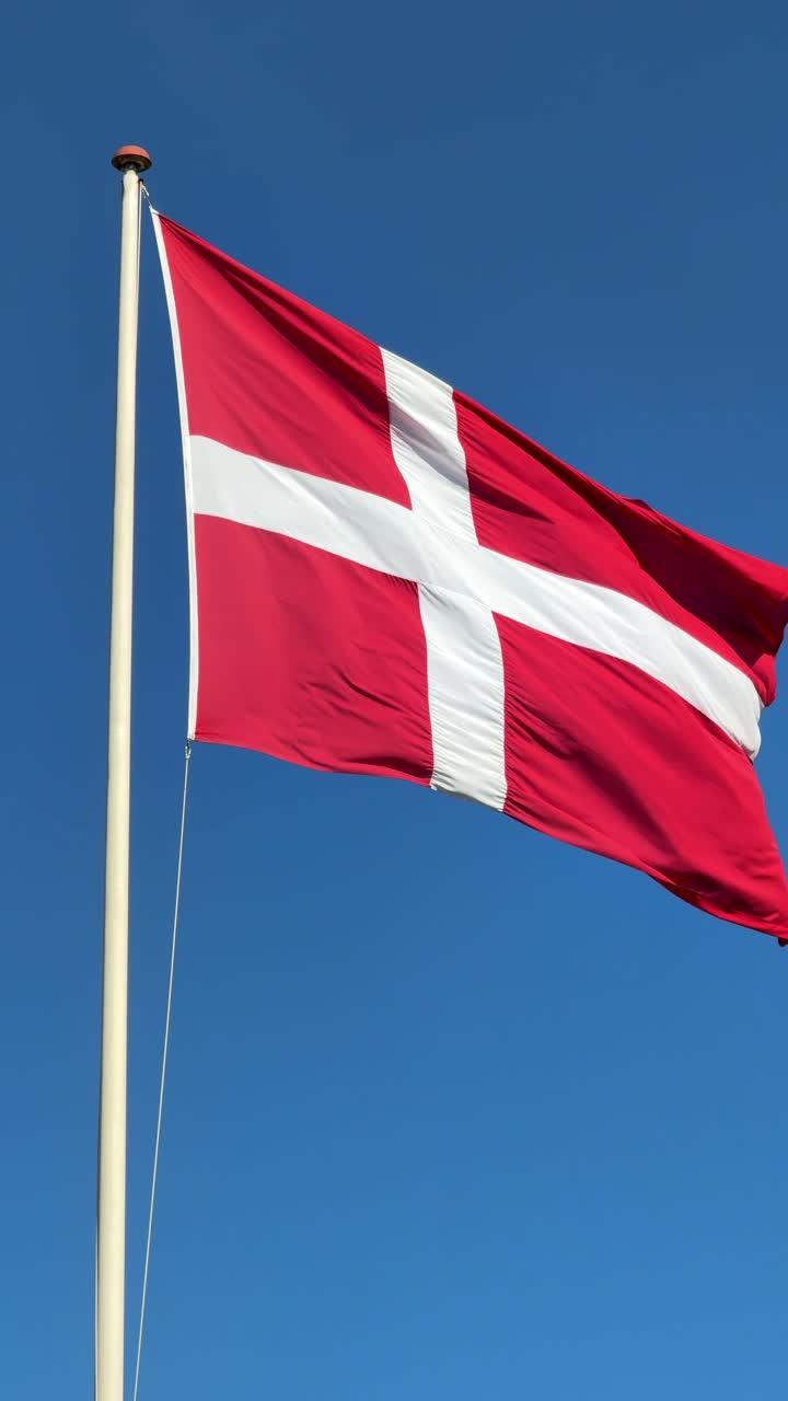 Dansk flag med blå himmel i baggrunden – slowmotion-video i lodret format