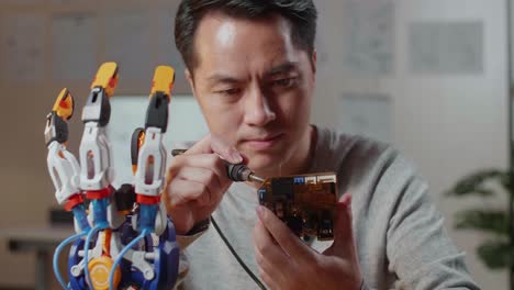 man repairing a robotic arm circuit board