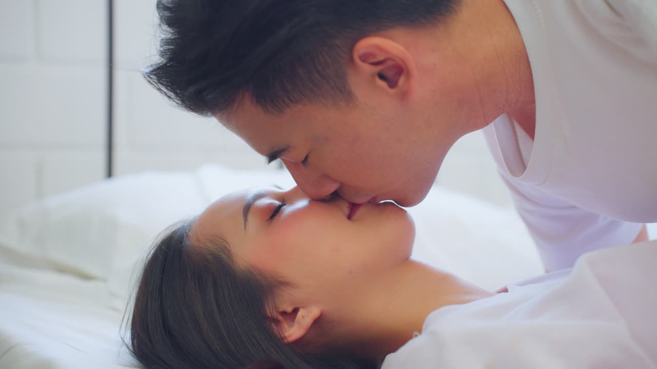 침대에서 키스하는 커플