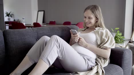 happy pregnant woman using smartphone