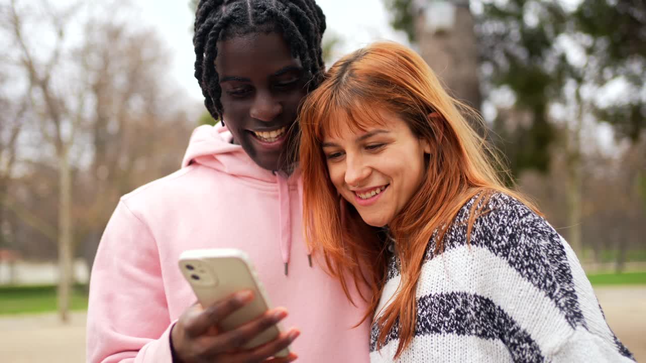 Coppia che guarda un telefono in un parco