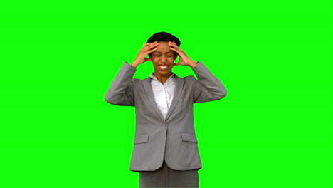 mujer de negocios furiosa sosteniendo su cabeza en la pantalla verde