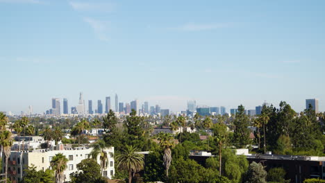 under the blazing midday sun of a hot summer day, downtown los angeles is seen from hollywood, facing southeast towards the bustling city center, capturing the vibrant energy of the metropolis