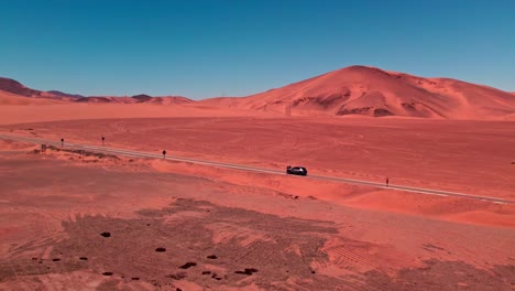 Vista-Aérea-De-Un-Automóvil-Conduciendo-Por-Una-Carretera-En-Medio-De-Dunas-En-Coquimbo,-Chile.