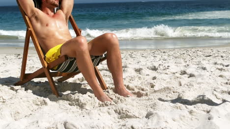 Man-relaxing-on-deck-chair-