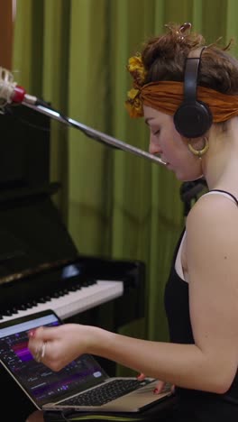 woman recording music in a studio with a piano
