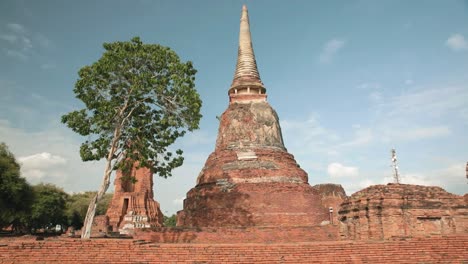 Wunderschöne-Pagode-Im-Wat-That-Maha-In-Ayutthaya,-Thailand-Mit-Einem-Baum-Vor-Blauem-Himmel