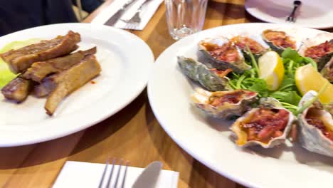 a sequence of gourmet dishes, including oysters and ribs, served in a well-lit restaurant setting in torquay, victoria