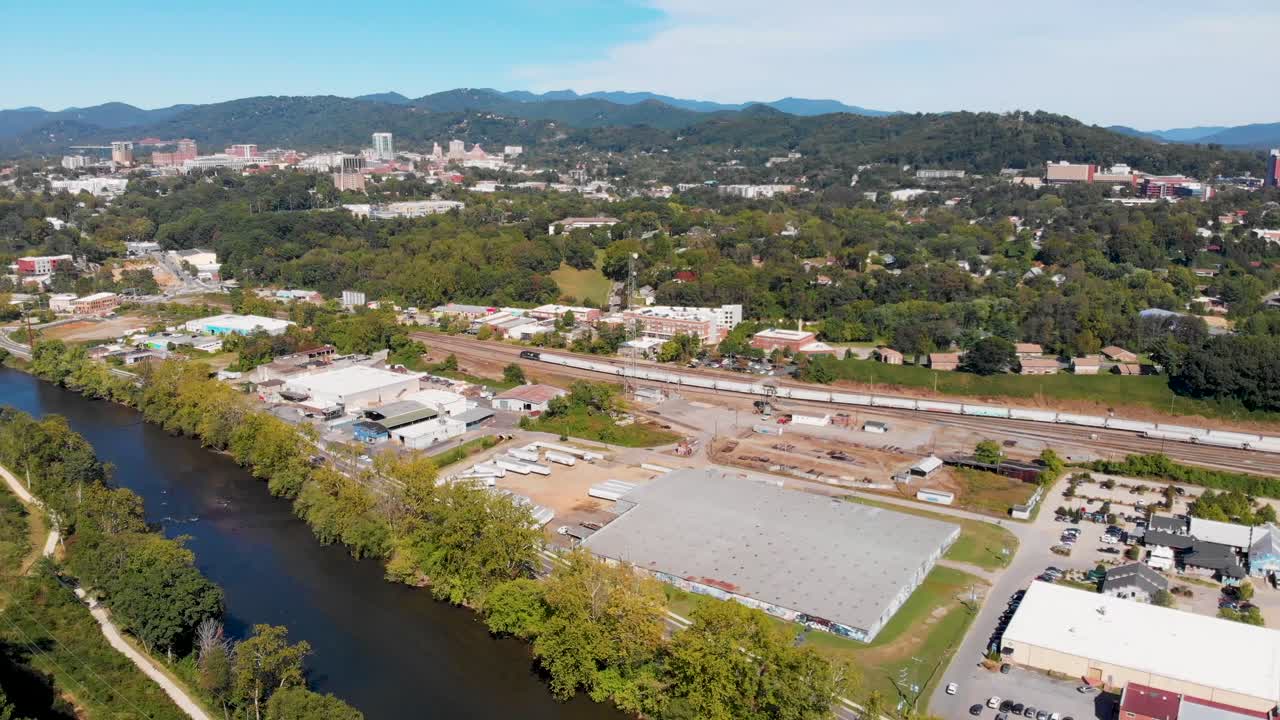 video aéreo de drones de 4k del patio de trenes del sur de norfolk y el distrito de artes fluviales a lo largo del amplio río francés en asheville, nc