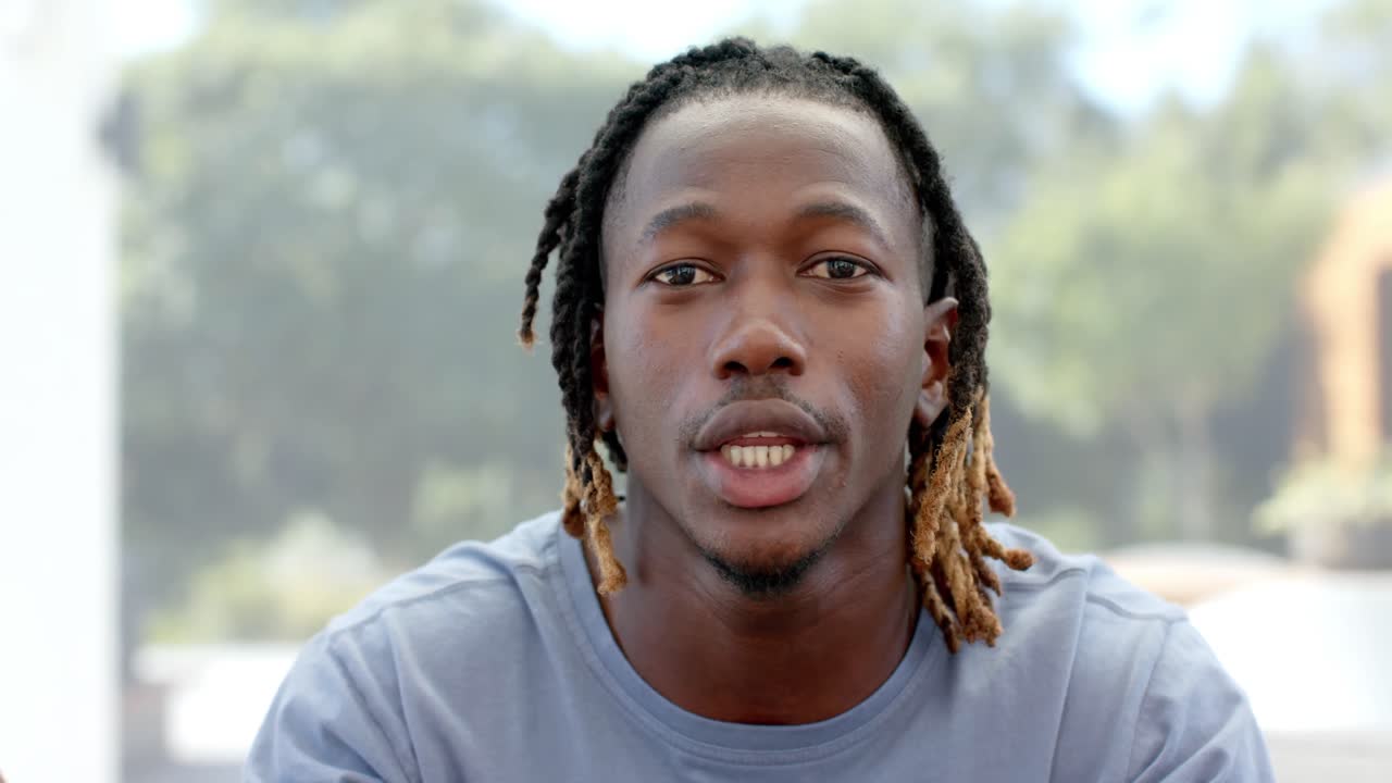 feliz hombre afroamericano haciendo una videollamada, hablando y gesticulando en casa, cámara lenta