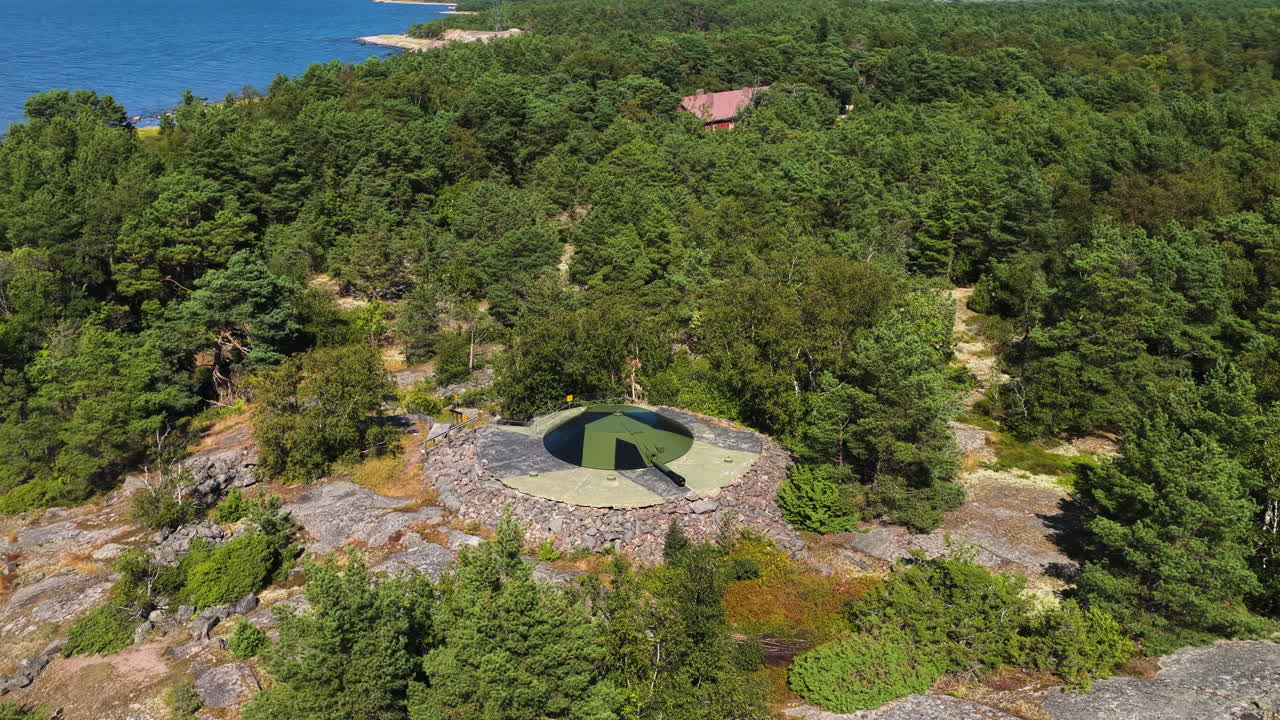 Panorama-Drohnenaufnahme um eine alte Kanone im Nordischen Archipel, Sommertag.