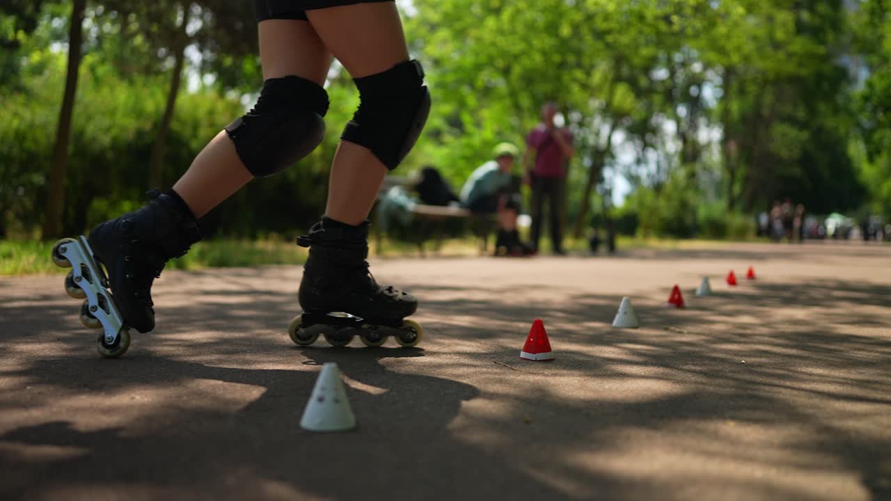 Woman roller skating on a park path with cones
