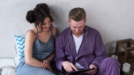 couple using tablet in pajamas