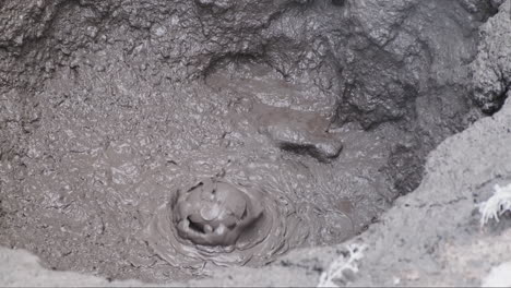 Slow-motion-footage-of-hot-mud-bubbles-bursting-up-from-a-geothermal-mud-pit