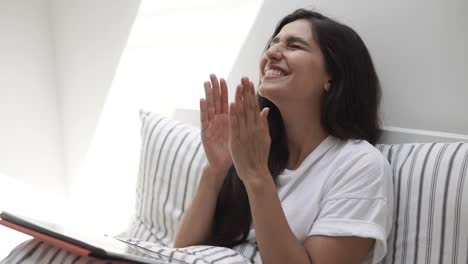 la mujer reacciona con emoción a algo en su tableta.