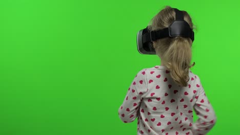 child girl using vr helmet to play simulation game app. watch virtual reality 3d video. chroma key