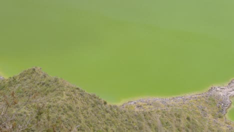 Peering-Over-the-Edge-to-Gaze-Down-at-the-Turquoise-Waters-of-Quilotoa-Lagoon-Inside-the-Caldera,-Ecuador