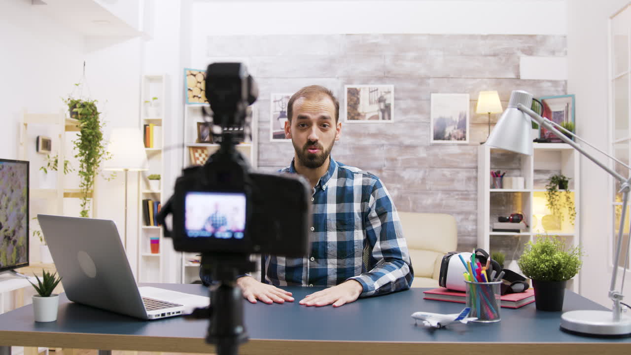 Man recording a vlog at his desk