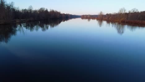 Gespiegelte-Reflexionen-Auf-Dem-Fluss,-Während-Die-Kamera-Vorbeiziehende-Wasservögel-Zurückfährt