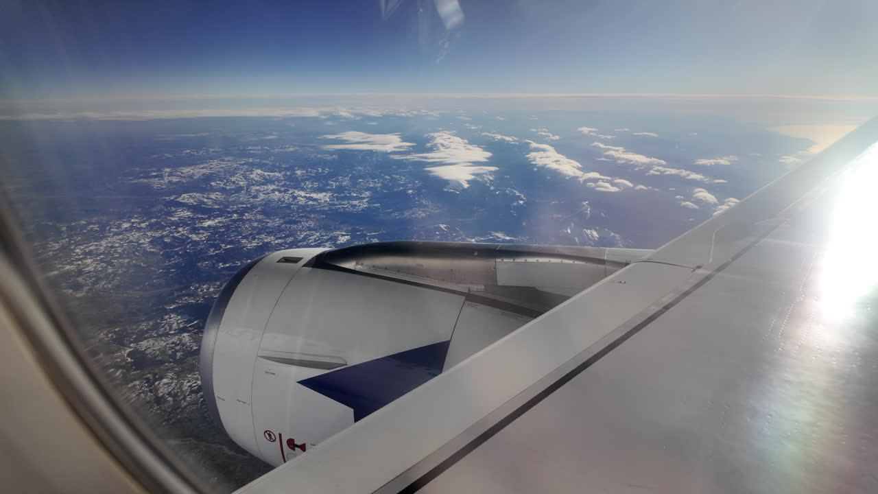 View from an airplane window of a mountain range and the sea