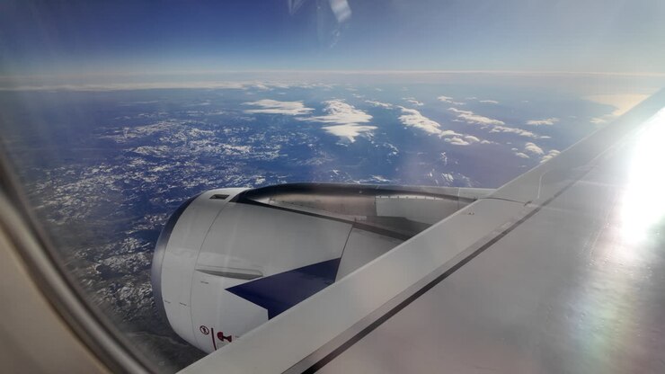 Vista da un finestrino di un aereo su una catena montuosa e il mare
