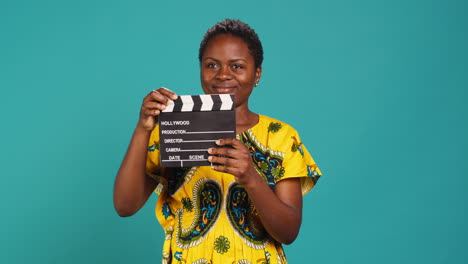 female film producer using a clapperboard to say action in movie industry