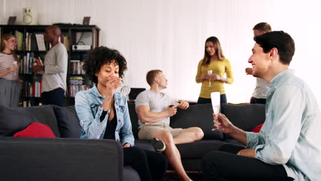 friends talking and drinking at a party in a loft apartment