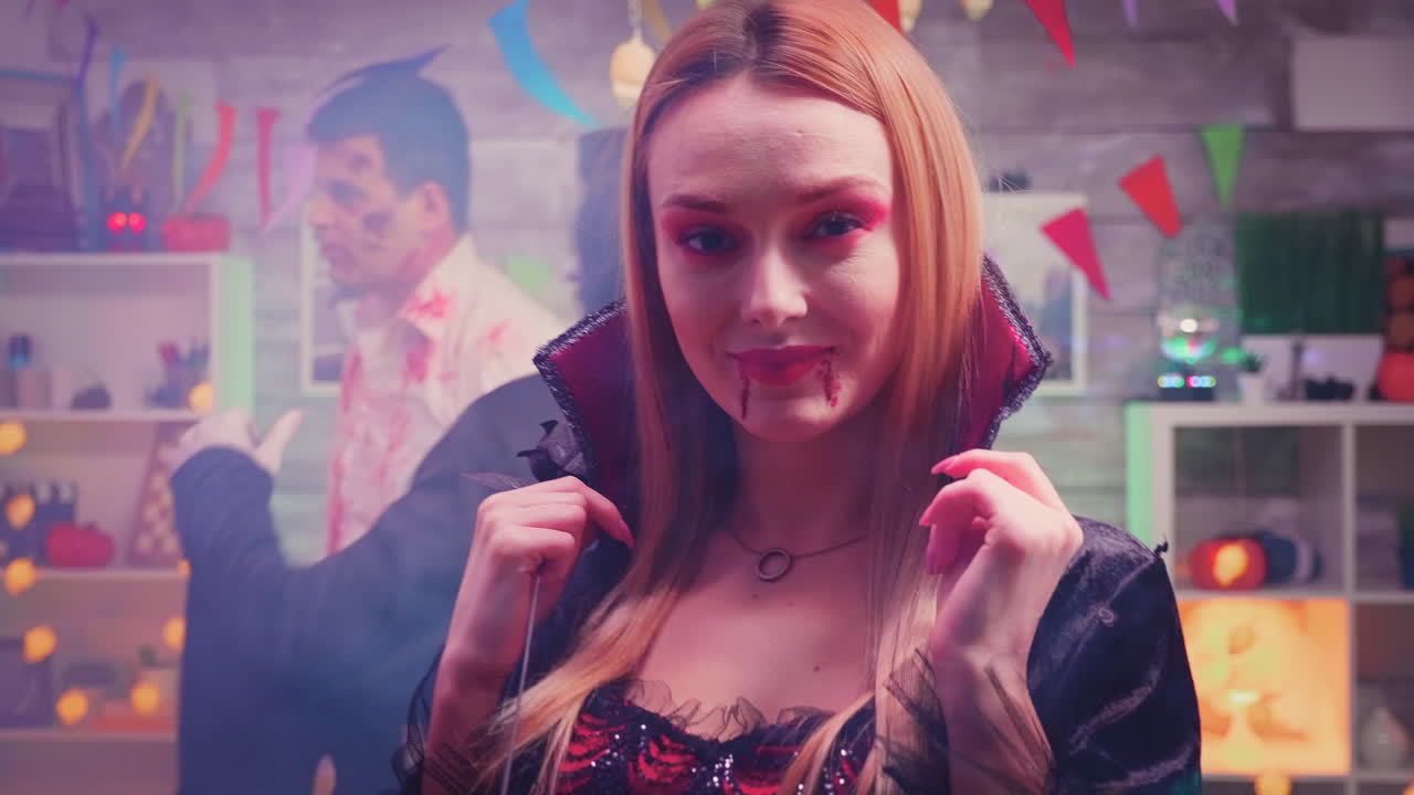 увеличить кадр женщины, одетой как ведьма с кровавым макияжем на лице