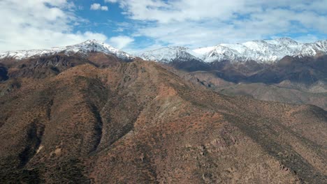 Camión-De-Vista-Aérea-A-La-Izquierda-Del-Parque-San-Carlos-De-Apoquindo,-Cordillera-Nevada-En-El-Fondo