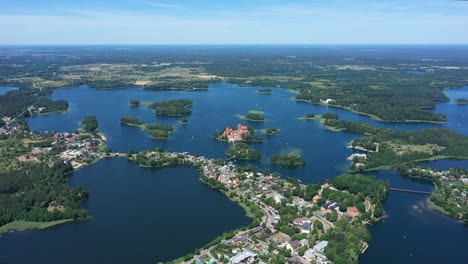 antena: volando a gran altura sobre la ciudad de trakai con el castillo de la isla de trakai visible en el fondo rodeado por un lago y un bosque