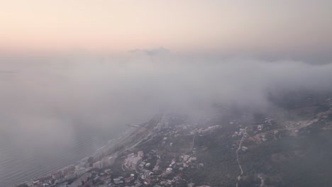 Seaside-city-is-revealed-under-the-clouds-during-sunset