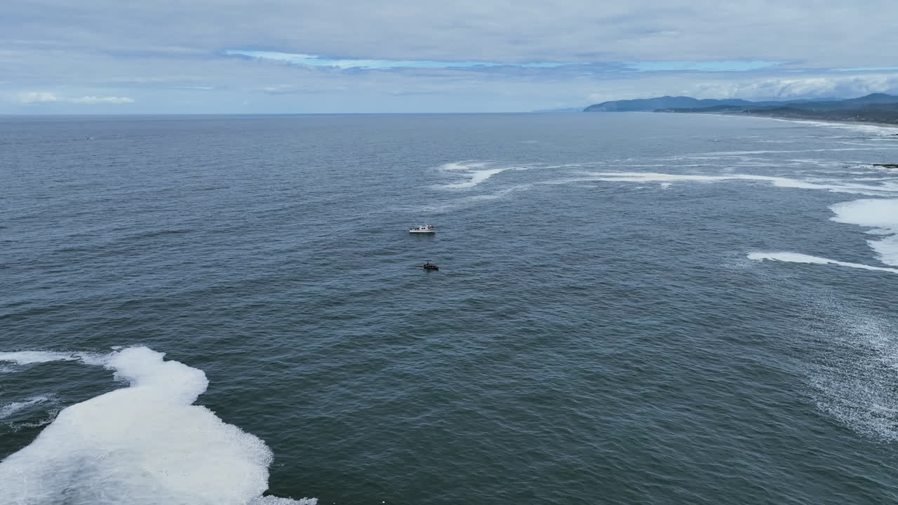 Aerial view rising over the Boiler Bay toward whale boats, in gloomy Oregon, USA