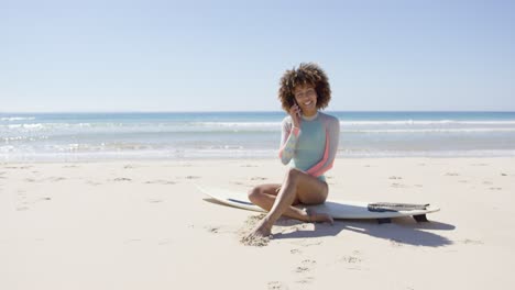 mujer hablando por teléfono en la playa