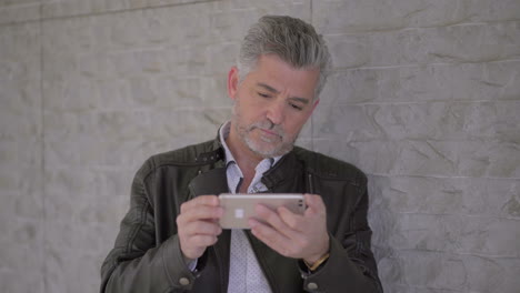 serious mature man using mobile phone