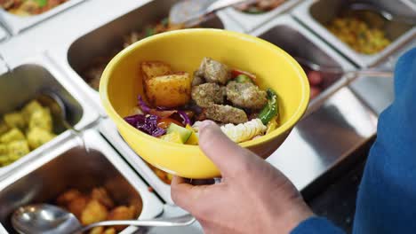 Person serving themselves a meal from a buffet line