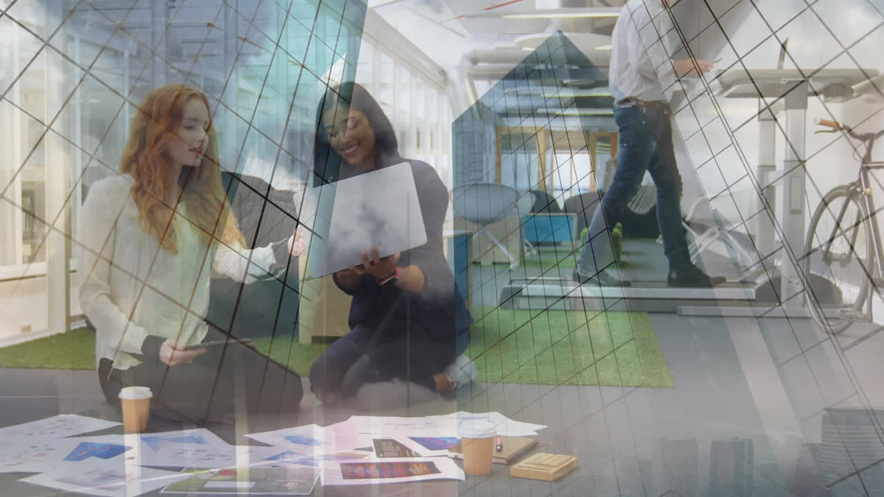 Animation of office building over businesswomen brainstorming and talking in modern office