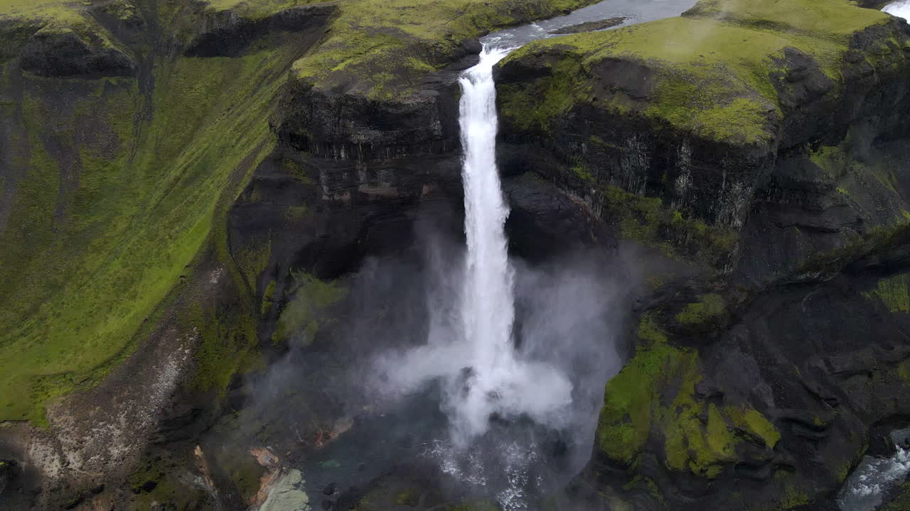 toma de seguimiento panorámica circular aérea de la asombrosa cascada de haifoss en el desfiladero de la montaña de fossárdalur, en islandia