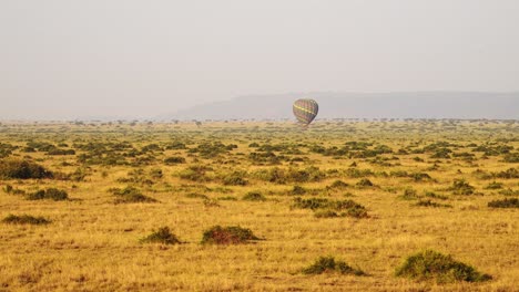 Hot-Air-Balloon-Flight-Ride,-High-View-Flying-Over-Maasai-Mara-Landscape-in-Africa,-Aerial-Shot-of-Beautiful-African-Savannah-Scenery-at-Sunrise-in-Amazing-Travel-Experience-Luxury-Ballooning-Trip