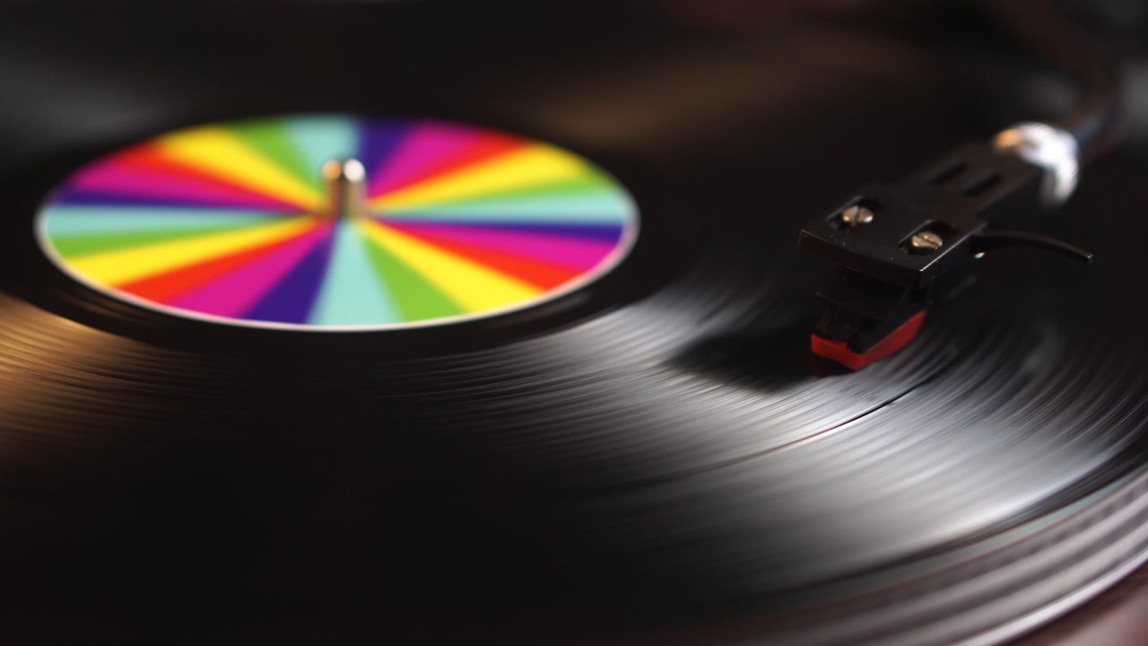 Spinning Vinyl Record With Rainbow Colors on Sticker and Crystal Needle, Close Up