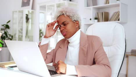 upset african american business woman using laptop doing difficult task