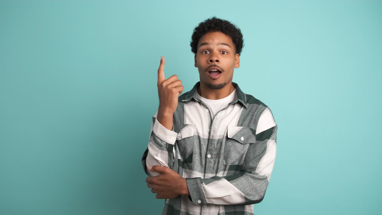 Thoughtful young man with great idea in blue studio