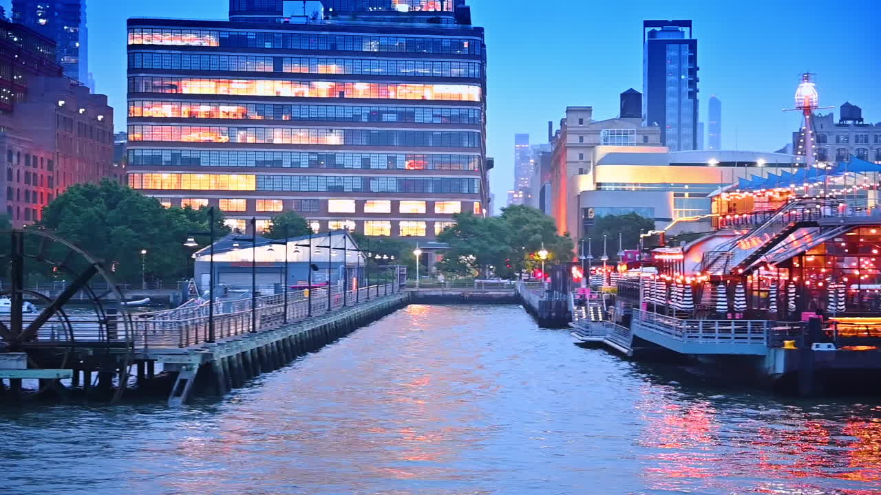 Waterfront of modern New York with beautiful piers and boats. River tour by the Hudson River at dusk time