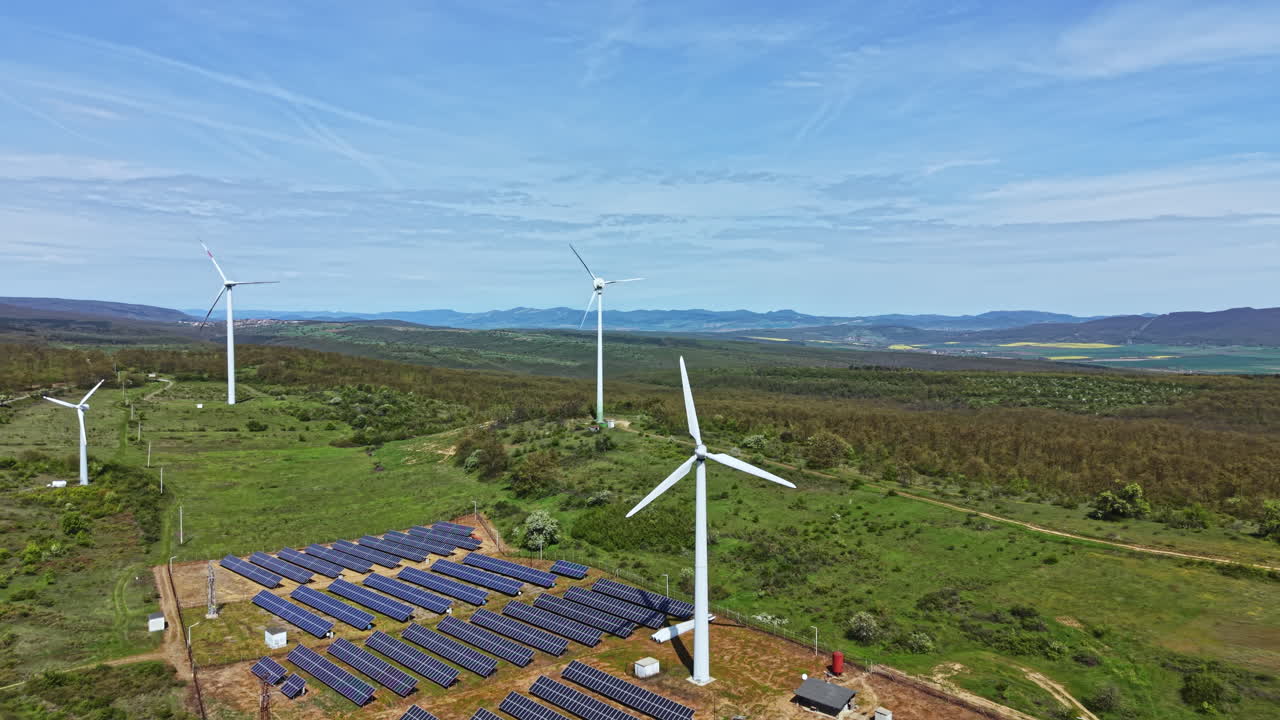 Vista de aerogeneradores y paneles solares en una planta de energía renovable en el campo durante el día